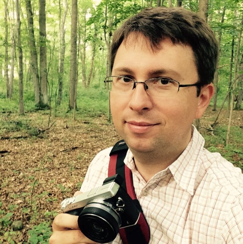 Keith Survell self portrait in a forest while holding a camera