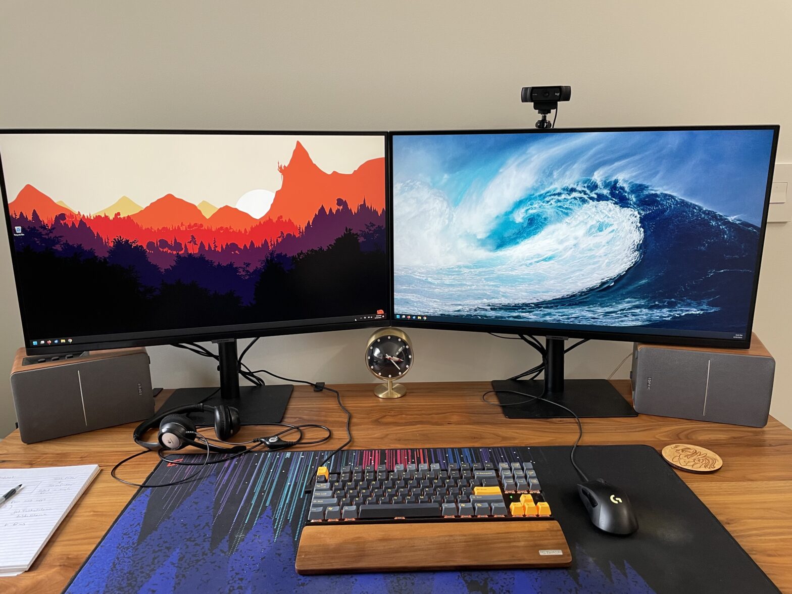 Dual Samsung 32 inch monitors side by side on a wood desk with a Keychron keyboard in the foreground